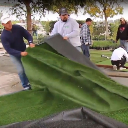 Installing synthetic grass pulling turf roll