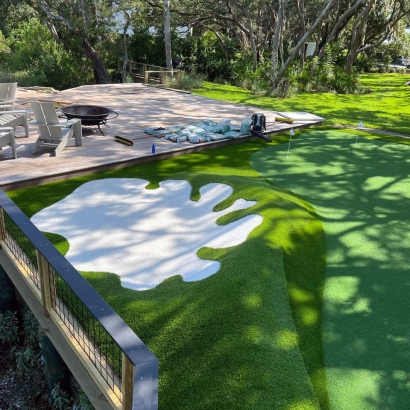 Backyard synthetic turf putting green with white bunker and deck seating in Sea Island, Georgia