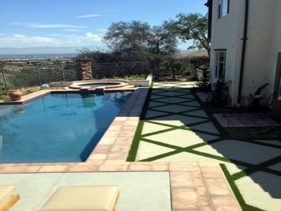 Artificial grass installed between pavers by swimming pool synthetic turf installation