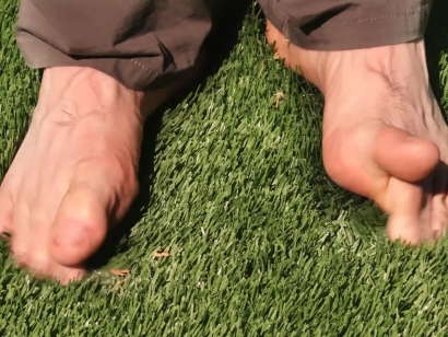 Bare feet of artificial grass green synthetic turf