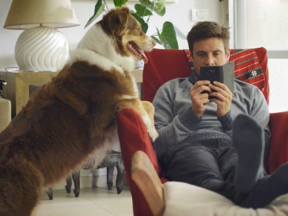 Man sitting in a chair buying online and a big dog