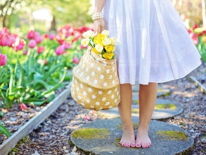 Woman in a garden with basket of flowers