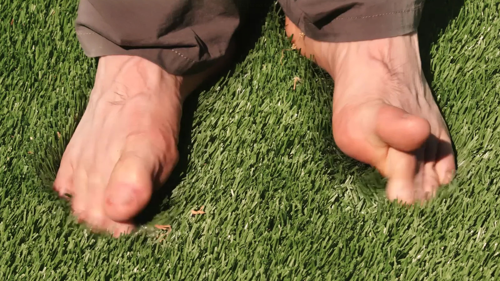 Bare feet of artificial grass green synthetic turf
